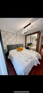 1 dormitorio con 1 cama blanca grande y espejo en Lugar de Alegría, Pegado a Playa, 2 Hab, 6 p, Wifi en Gijón