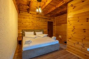 1 dormitorio con 1 cama en una habitación de madera en Theth Kompleksi Gjoni en Theth