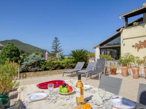 a table with a bottle of wine and a bowl of fruit at Apartment La Madrague d'Azur-7 by Interhome in La Madrague