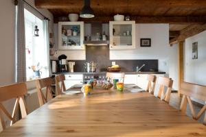 una cocina con una mesa de madera larga y sillas en Ferienhaus "Am Bodeweg 1" en Schierke
