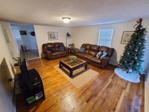 sala de estar con sofá y árbol de Navidad en Little Garden House, en Pine Mountain