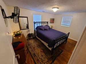 um quarto com uma cama com lençóis roxos e um espelho em Little Garden House em Pine Mountain