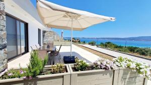 une terrasse avec une table et un parasol dans l'établissement Υπόσκαφα cave concept, à Amoliani