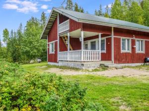ein rotes Haus mit einer Veranda und einem Hof in der Unterkunft Holiday Home Otsola by Interhome in Lahdenkylä