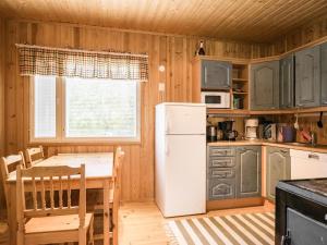 LahdenkyläにあるHoliday Home Otsolaのキッチン(白い冷蔵庫、テーブル付)