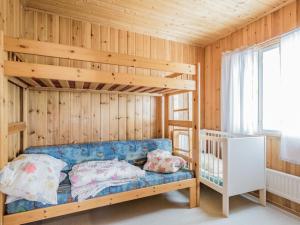 ein Schlafzimmer mit einem Etagenbett und einem blauen Sofa in der Unterkunft Holiday Home Otsola by Interhome in Lahdenkylä