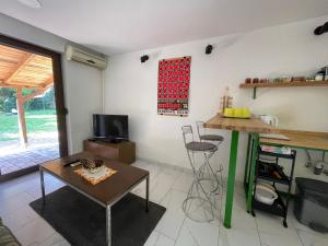 - un salon avec une table, une table et une télévision dans l'établissement PB Garden Apartman, à Sremska Mitrovica