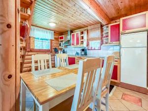 KinnulaにあるHoliday Home Kaakonranta by Interhomeのキッチン(木製テーブル、冷蔵庫付)