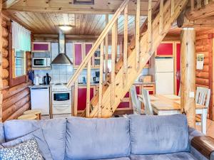 - un salon avec un canapé bleu dans une cabane en rondins dans l'établissement Holiday Home Kaakonranta by Interhome, à Kinnula