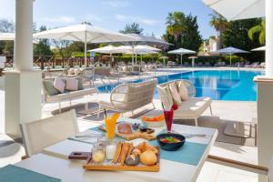 a tray of food on a table next to a pool at Martinhal Quinta Family Resort in Quinta do Lago