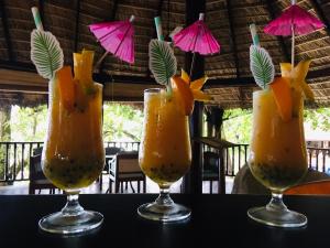 three glasses with fruit in them sitting on a table at Cerf Island Resort in Cerf Island