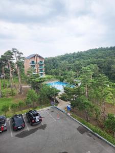 a parking lot with cars parked in front of a river at Sokcho Daemyung Heidi Pension in Sokcho