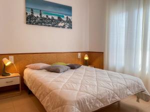 a bedroom with a large bed with two pillows at Apartment Roger de Flor-1 by Interhome in Llança