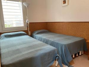 two twin beds in a room with a window at Apartment Roger de Flor-1 by Interhome in Llança