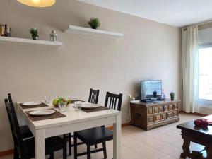 a dining room with a table and chairs and a television at Apartment Roger de Flor-1 by Interhome in Llança