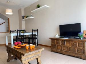 a living room with a television and a table with fruit on it at Apartment Roger de Flor-1 by Interhome in Llança