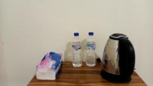 dos botellas de agua sentadas en un estante de madera en Benedict Guesthouse by Mori Hospitality en Labuan Bajo