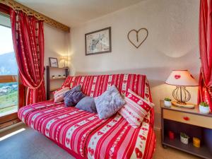 a bedroom with a bed with a red and white blanket at Studio Vostok Zodiaque-79 by Interhome in Le Corbier