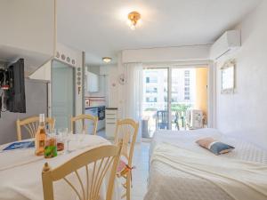 Habitación con 2 camas, mesa y cocina. en Apartment Les Rives Latines by Interhome en Fréjus