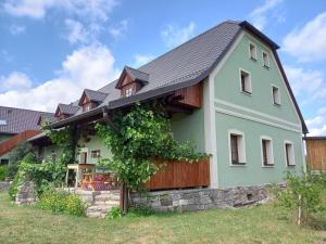 a green house with a gray roof at Chalupa U Kravína in Rtyně v Podkrkonoší