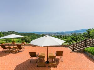 un patio con sillas y una mesa con sombrilla en Holiday Home Grotte Rosse by Interhome, en Cinigiano