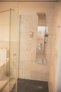 a shower with a glass door in a bathroom at Trigo Homes in Córdoba