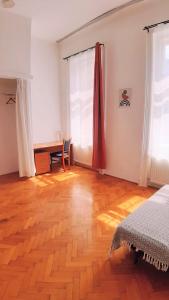 1 dormitorio con suelo de madera, escritorio y ventana en Citypark Classic Downtown Apartment, en Budapest