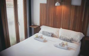 Un dormitorio con una cama blanca con toallas. en Trigo Homes en Córdoba