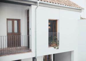 a white house with two balconies and a door at Trigo Homes in Córdoba
