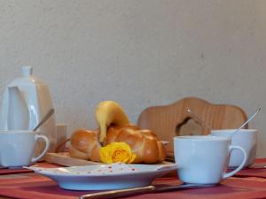 a table with two cups and a plate of bread at Apartment Ecluses 2 by Interhome in Nendaz