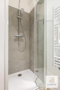 a shower with a glass door in a bathroom at Residence Poterne in Valenciennes