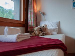 two teddy bears sitting on top of a bed at Apartment Ecluses 2 by Interhome in Nendaz
