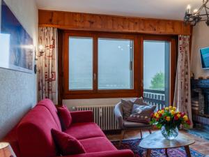 a living room with a red couch and a table at Apartment Ecluses 2 by Interhome in Nendaz