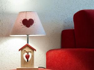 a bird house with a heart painted on it next to a red chair at Apartment Ecluses 2 by Interhome in Nendaz