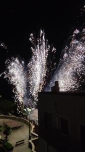 Un mucchio di fuochi d'artificio che esplodevano nel cielo di notte. di DIMORA STORICA ALLA ROTONDA a Mottola