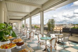 Habitación con mesas y sillas en el balcón. en UNAHOTELS Trastevere Roma, en Roma