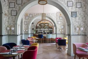 um restaurante com mesas e cadeiras e um bar em UNAHOTELS Trastevere Roma em Roma