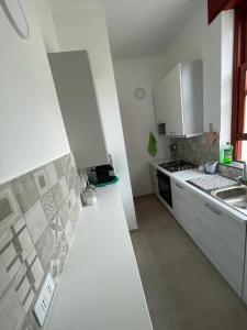 Una cocina con gabinetes blancos y una encimera blanca. en Sul lungo mare posizione unica, en San Vito lo Capo