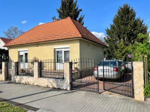 a house with a fence and a car parked in front at Budapest Airport Smiley House in Gyál