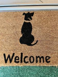 um tapete de boas-vindas com uma sombra de um cão sobre ele em Budapest Airport Smiley House em Gyál