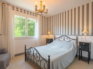 a bedroom with a bed and a chandelier at Apartment Domaine des Fées by Interhome in Saint-Palais-sur-Mer