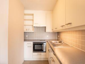 ブレーデネにあるApartment Residentie Zandloper II by Interhomeの白いキャビネットとシンク付きのキッチン