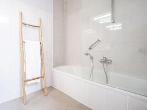 La salle de bains blanche est pourvue d'une baignoire et d'une douche. dans l'établissement Apartment Residentie Zandloper II by Interhome, à Bredene