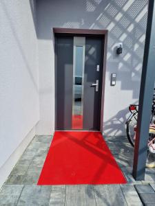 a red rug is in front of a door at Rhein Appartements in Rheinhausen