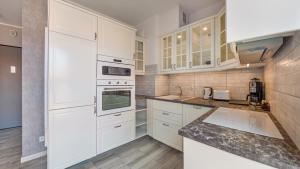 kuchnia z białymi szafkami i białymi urządzeniami w obiekcie Apartamenty Sun & Snow Deo Plaza Granaria w Gdańsku