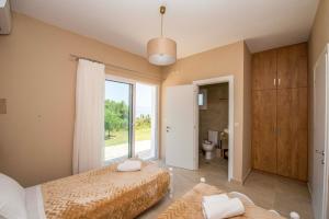a bedroom with two beds and a large window at Astrakeri Sea Side Hill in Astrakeri