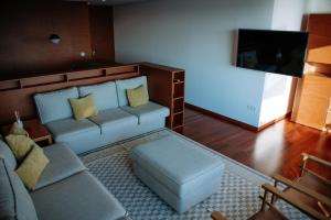 a living room with a couch and a tv at Apartamento Luxo T3 Vista Mar-Tritão in Vila do Conde