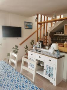 1 dormitorio con 1 cama, lavamanos y mesa en La Finestra Sul Mare, en Stintino