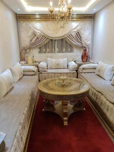 a large living room with a table and couches at Complexe zohour in Tangier