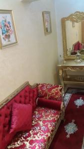 a living room with a couch and a mirror at Complexe zohour in Tangier